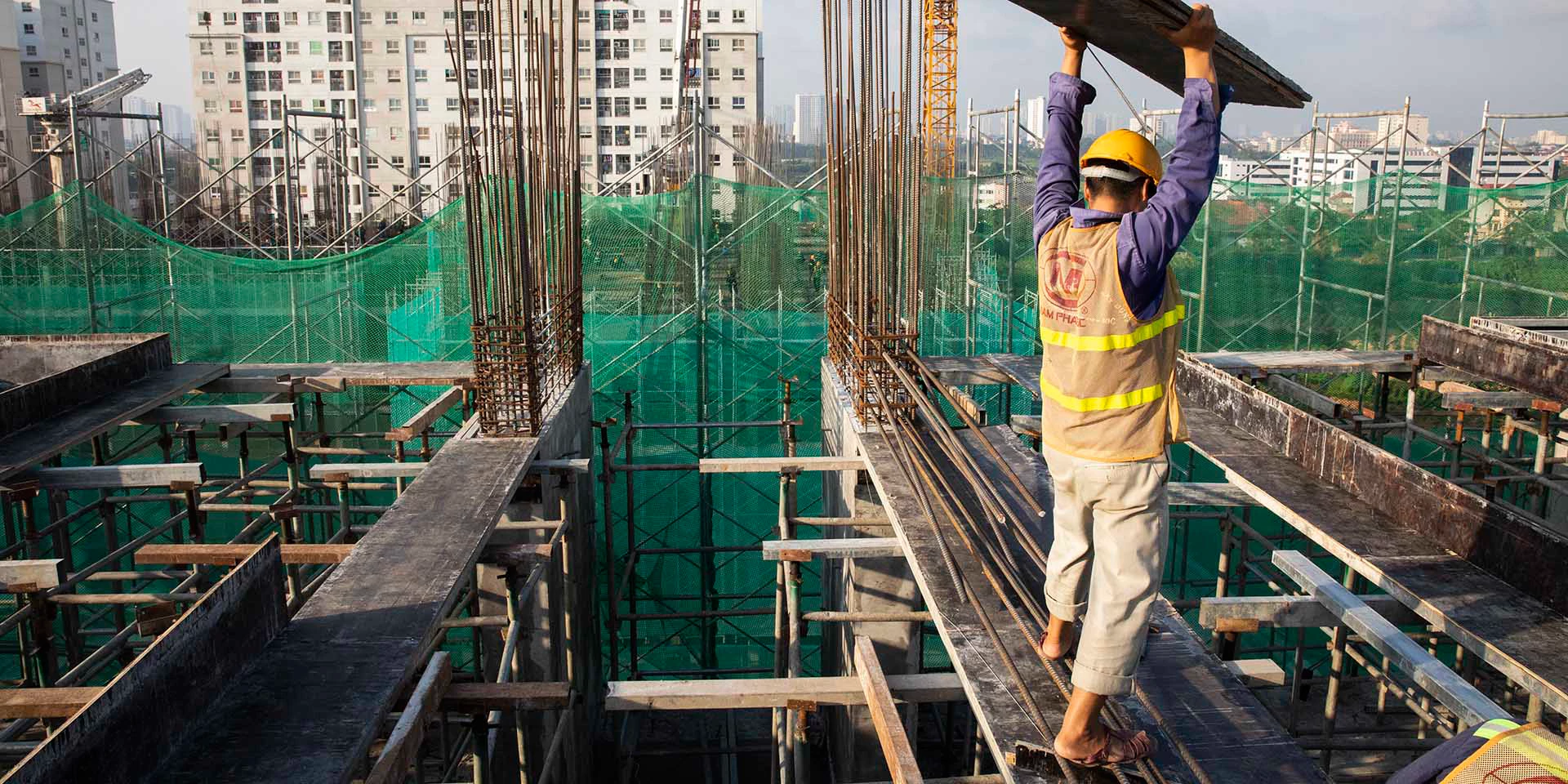 CNX construction workers carefully lay concrete forms in preparation to pour concrete on the upper floors of an apartment building in Hanoi, Vietnam on July 27, 2019. This construction project is an EDGE certified building, an affordable and sustainable housing development in Hanoi. Photo Â© Dominic Chavez/International Finance Corporation