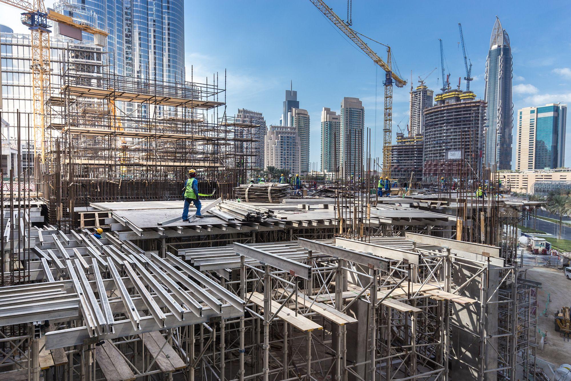 Ouvriers travaillant sur un chantier de construction moderne à Dubaï.
